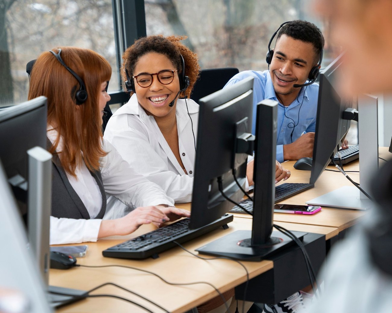 Equipo de servicio al cliente de LTO atendiendo llamadas con auriculares en la oficina